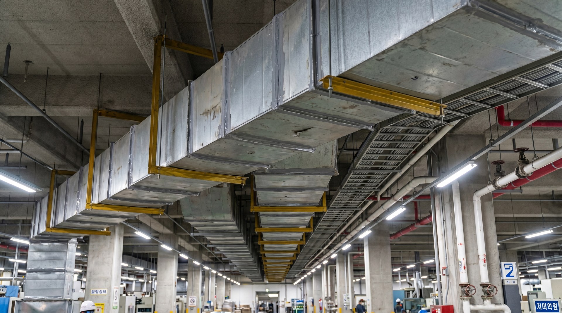 AEROCLAD Smoke Duct · 대규모 공장·물류센터 적용 · 노란 브라켓 + 다층 MEP + 대공간 사각 덕트